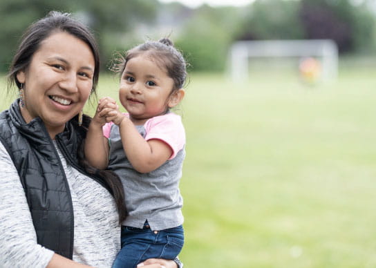 BOKF supports native american housing for individuals such as this person holding their child. 