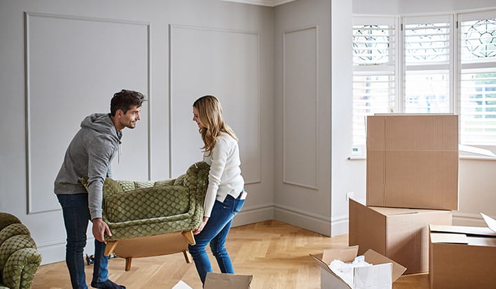 Young couple moving in with furniture excited about their new home purchase through BOK.