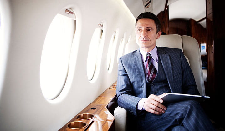 Business owner on private jet researching aircraft financing options through BOK. 