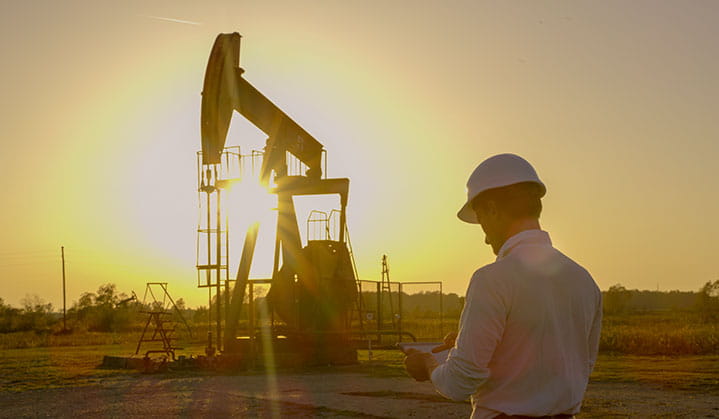 BOK mineral asset manager by oil and gas machine at sunset.