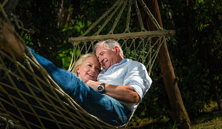 Couple relaxing in hammock after finalizing estate management & planning