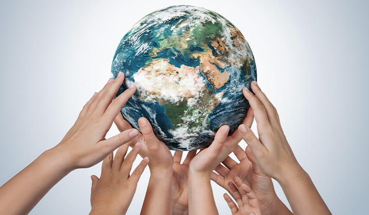 Hands around globe of earth showing common values and unity.