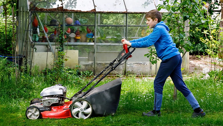 Photo of boy pushing a lawn mower