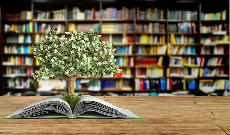 A money tree growing out of a book to show how improving your financial skills starts with a budget.
